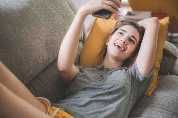 women smiling while holding her phone